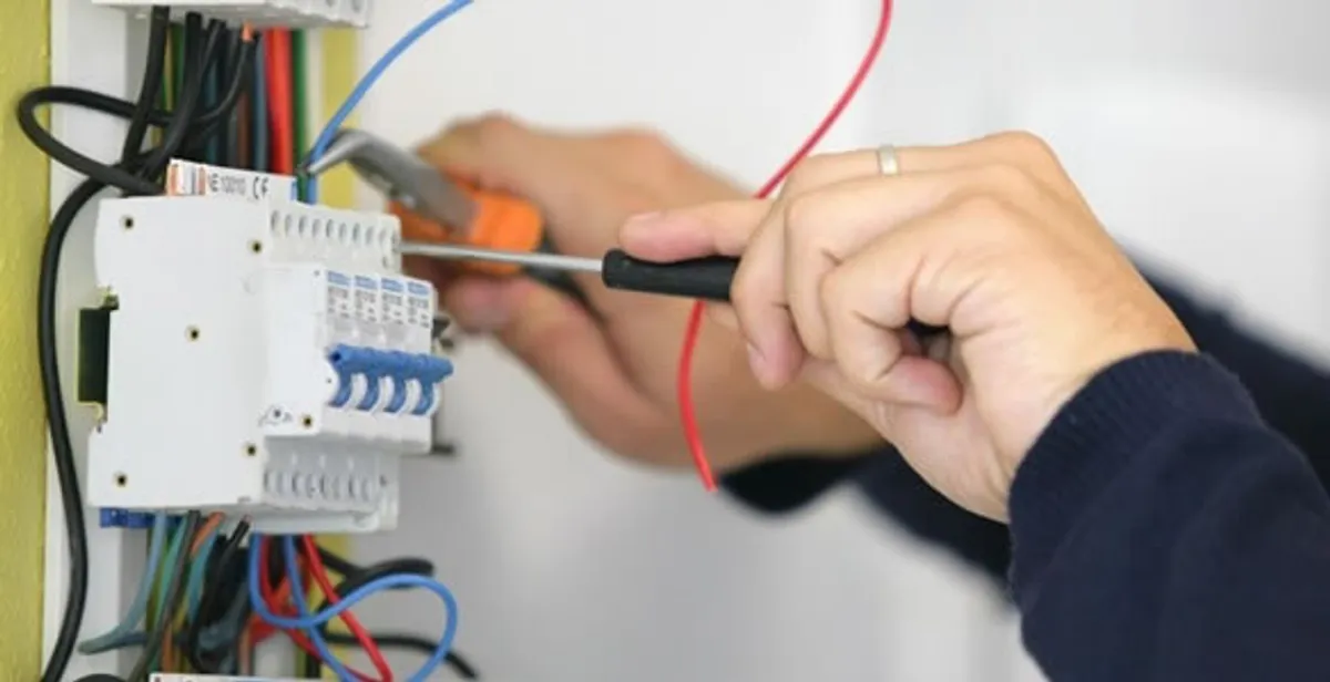 Electrician installing and adjusting circuit breakers in an electrical panel in West Palm Beach, FL