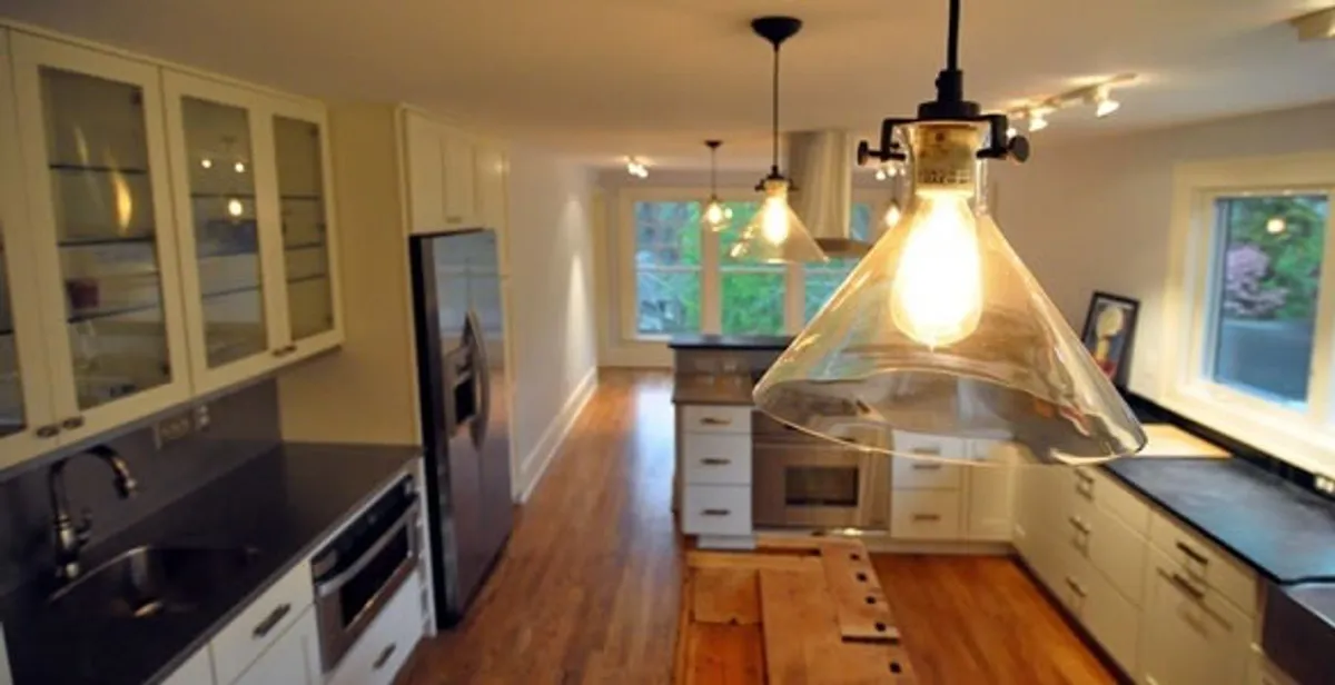 Residential electrician installing modern indoor light fixture in a home in West Palm Beach, FL